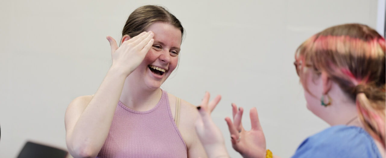Header image of two women using American Sign Language