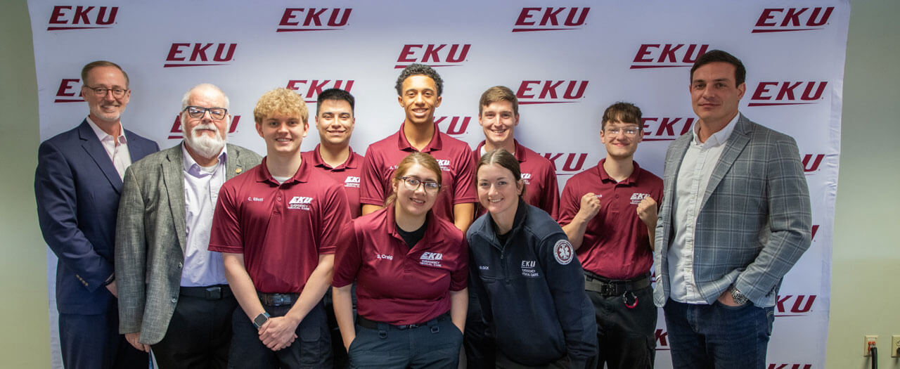 Faculty and staff from EKU's College of Justice, Safety & Military Science post for a photo with alumnus Dr. Andrew Napier.