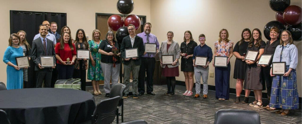 Banner image of a line of faculty holding up their awards