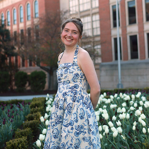 Photo student Kenlee Ehr standing in front of tulips
