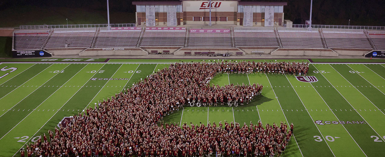 Banner image of students on a sports field creating the EKU E logo