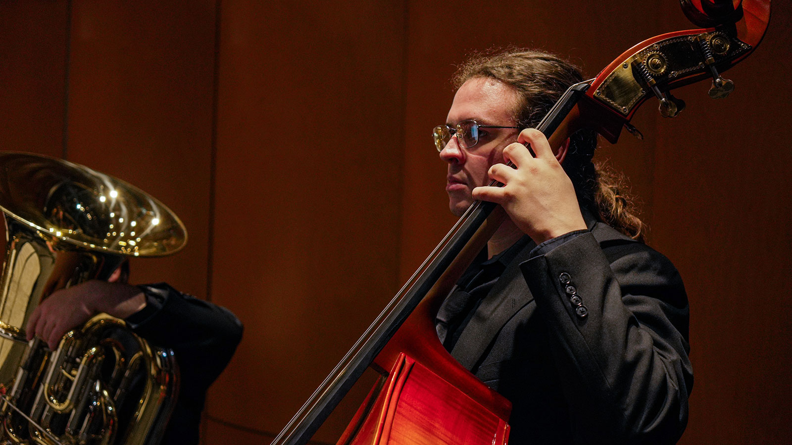 Male student cello player performing in a group