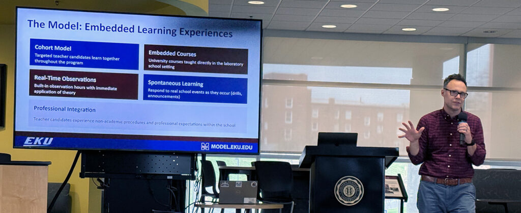 Dr. Peter Edwards presenting in front of video screen