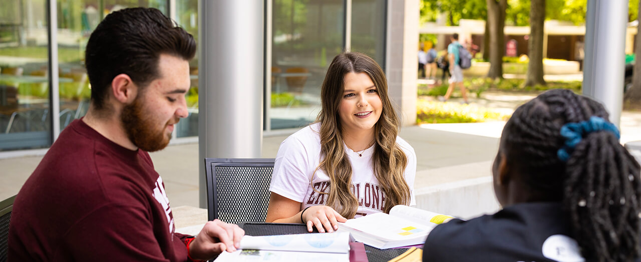 Banner image of EKU students sitting around a table talking