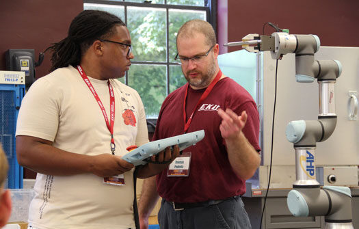 EKU professor Thomas Podesta stands next to student and provides instruction